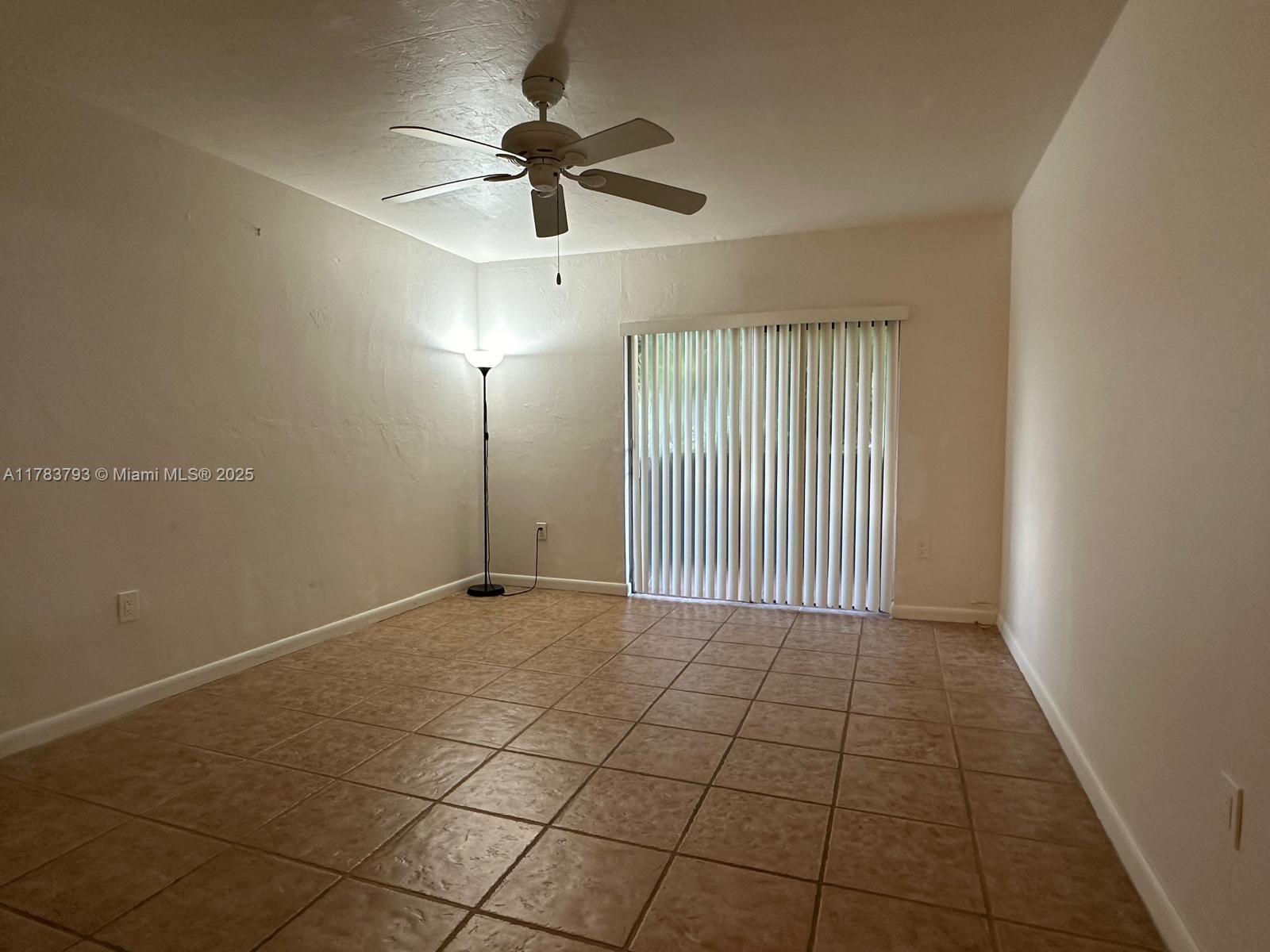 8335 Southwest 72nd Avenue, Unit 202D Miami, FL 33143 - Photo 11 of 24 a view of a livingroom with a ceiling fan and window