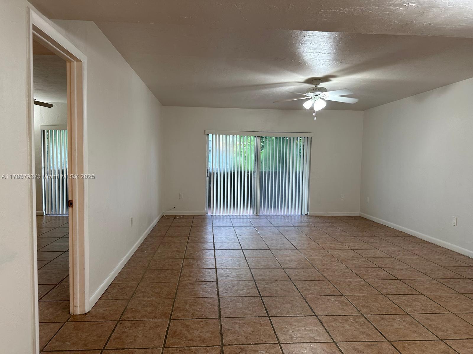 8335 Southwest 72nd Avenue, Unit 202D Miami, FL 33143 - Photo 8 of 24 en empty room with windows and fan