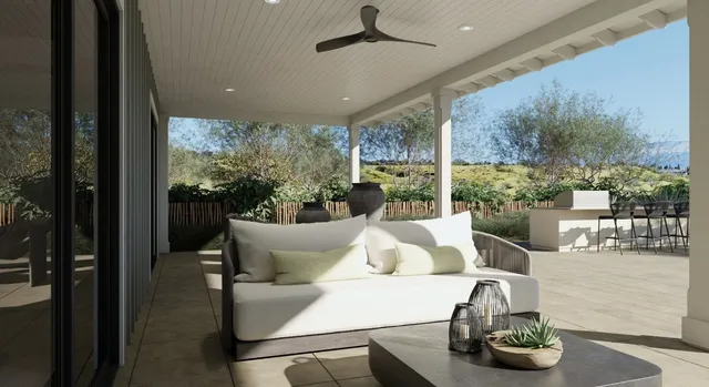 a living room with patio furniture and a potted plants