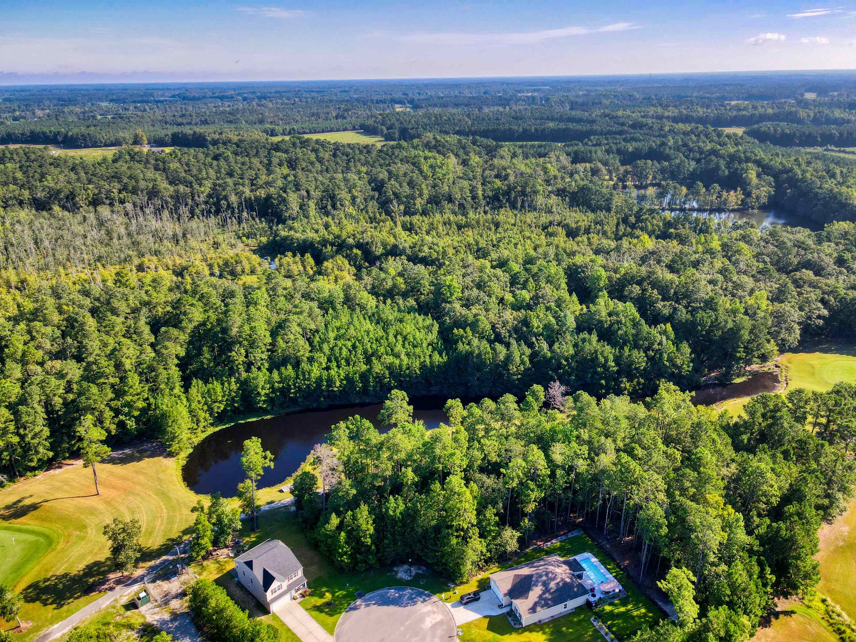Aerial view of property and surrounding area with a nearby body of water