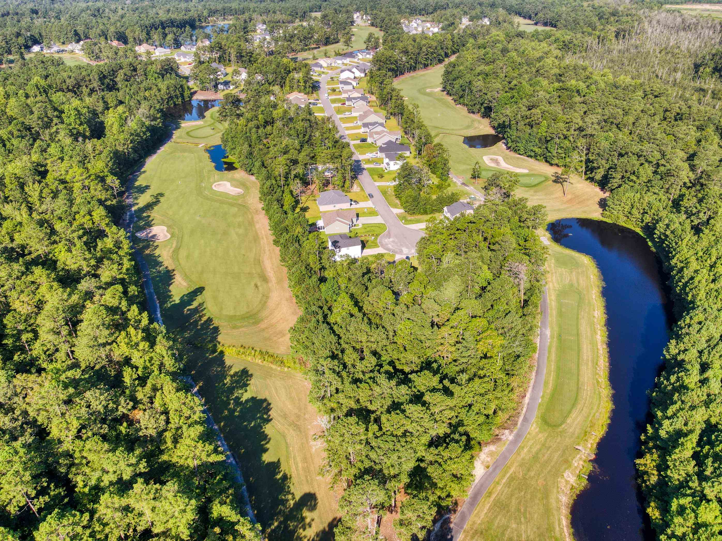 677 Timber Creek Drive Loris, SC 29569 - Photo 13 of 33 Aerial view of property's location featuring a golf course and a heavily wooded area