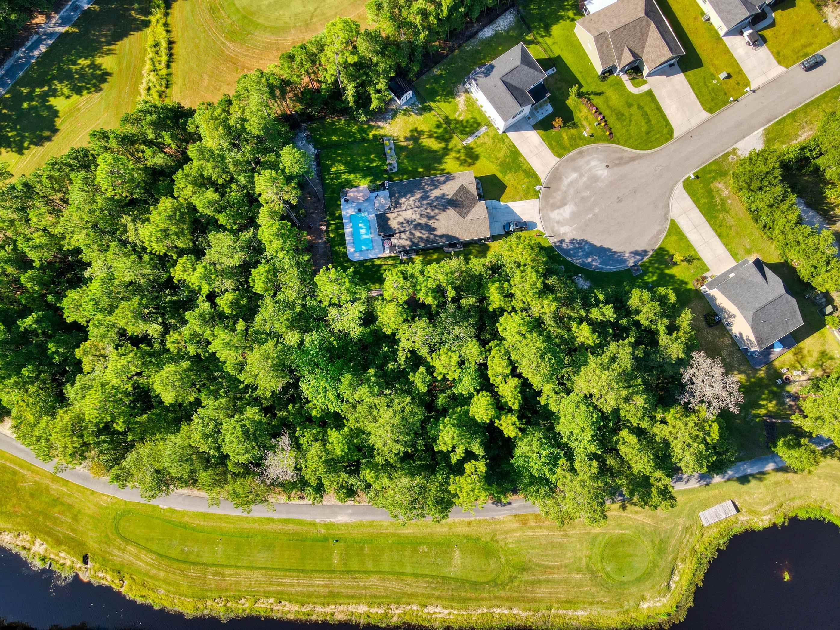 677 Timber Creek Drive Loris, SC 29569 - Photo 21 of 33 Aerial overview of property's location with a local golf course, a large body of water, and nearby suburban area