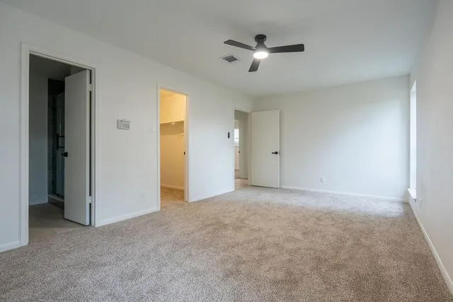 an empty room with fan and windows