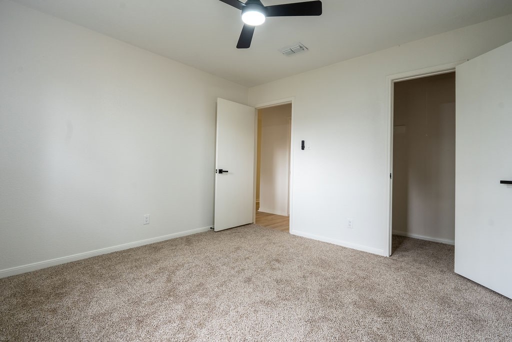 23230 Briarcreek Boulevard Spring, TX 77373 - Photo 17 of 32 an empty room with a ceiling fan and carpet
