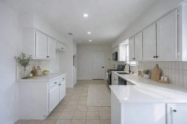 a kitchen with stainless steel appliances a sink stove and cabinets