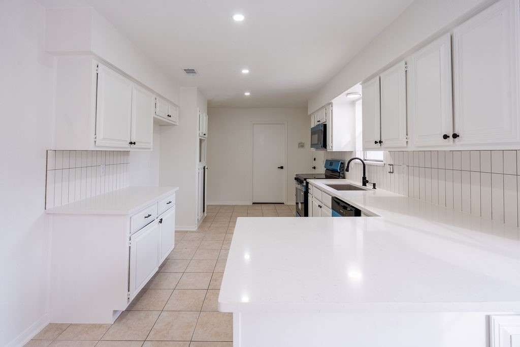 23230 Briarcreek Boulevard Spring, TX 77373 - Photo 8 of 32 a large white kitchen with cabinets