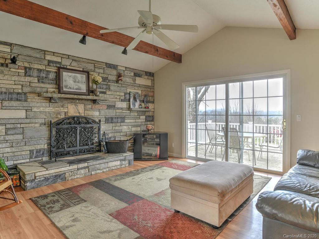 321 Gouges Branch Road Leicester, NC 28748 - Photo 14 of 48 a living room with a bed a fireplace and next to a window