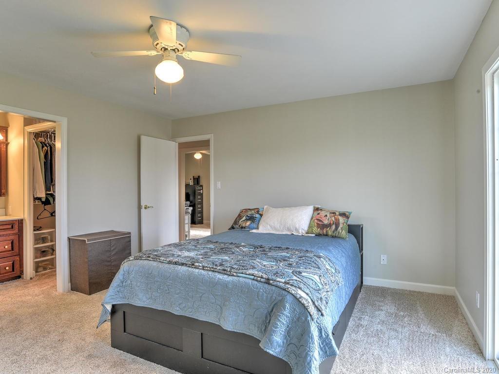 321 Gouges Branch Road Leicester, NC 28748 - Photo 27 of 48 a bedroom with a bed and a chandelier