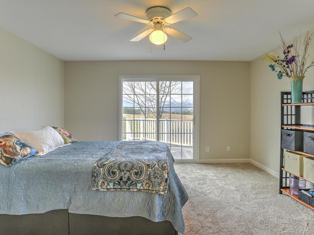 321 Gouges Branch Road Leicester, NC 28748 - Photo 28 of 48 a bedroom with a bed and a chandelier