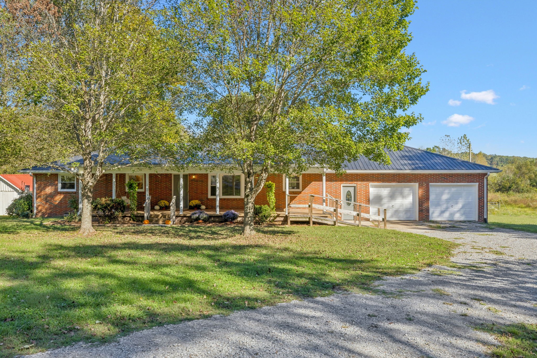 a front view of house with yard and trees in the background