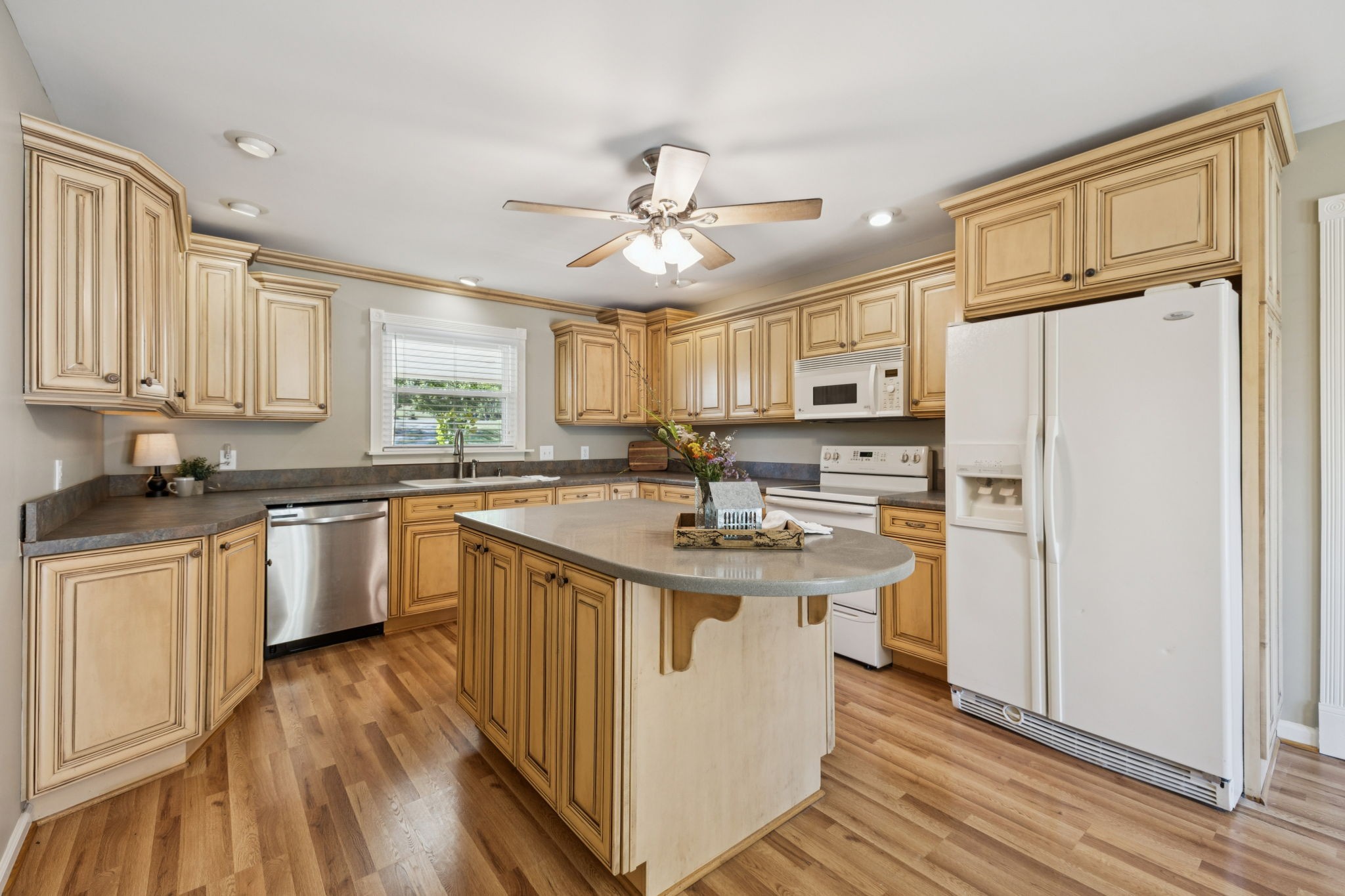 10446 Bold Springs Road McEwen, TN 37101 - Photo 14 of 54 a kitchen with stainless steel appliances granite countertop a refrigerator a sink dishwasher a stove and white countertops with wooden floor