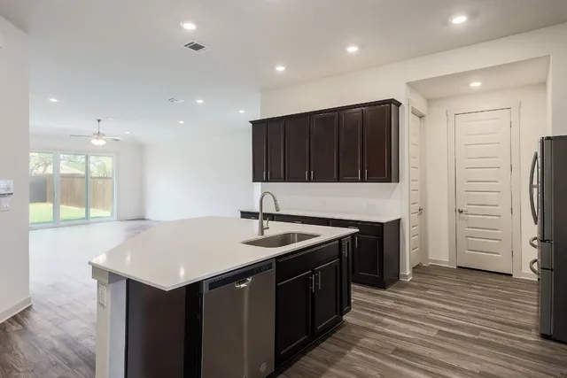 a kitchen with stainless steel appliances granite countertop a sink stove and refrigerator
