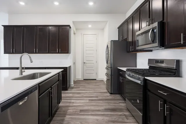 a kitchen with stainless steel appliances granite countertop a sink stove and refrigerator