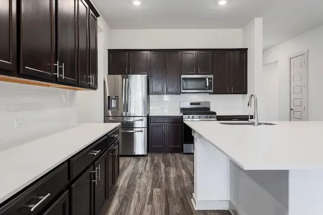 a kitchen with stainless steel appliances a refrigerator sink and stove