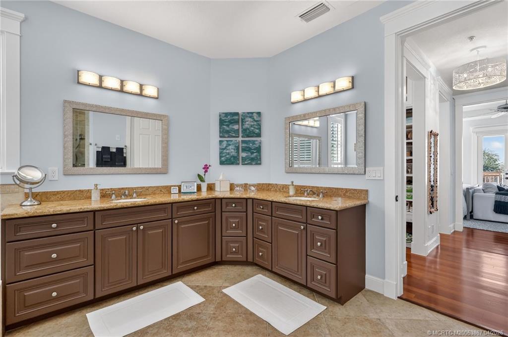 334 Southwest Atlanta Avenue Stuart, FL 34994 - Photo 29 of 56 a spacious bathroom with a granite countertop sink and a large mirror