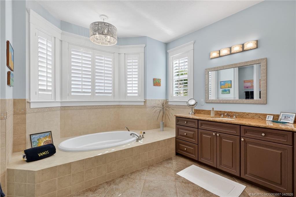 334 Southwest Atlanta Avenue Stuart, FL 34994 - Photo 30 of 56 a bathroom with a tub sink and a mirror