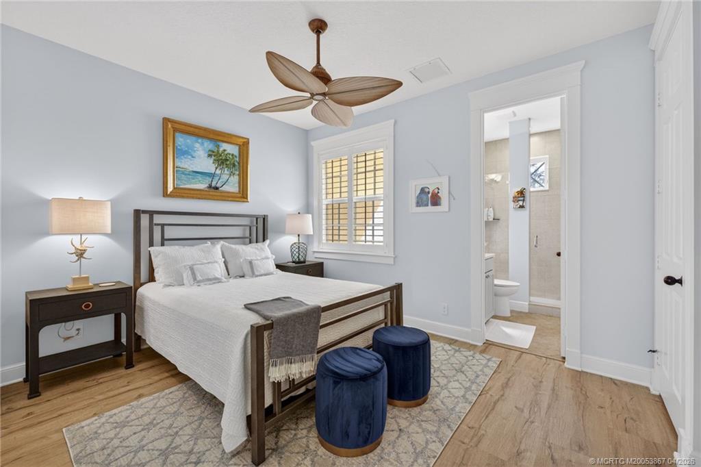 334 Southwest Atlanta Avenue Stuart, FL 34994 - Photo 33 of 56 a bedroom with a bed and a chandelier