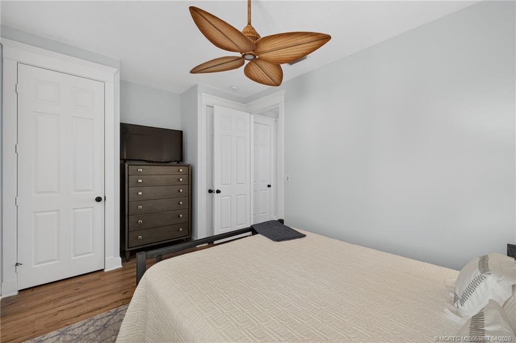 334 Southwest Atlanta Avenue Stuart, FL 34994 - Photo 34 of 56 a bedroom with a bed and a chandelier