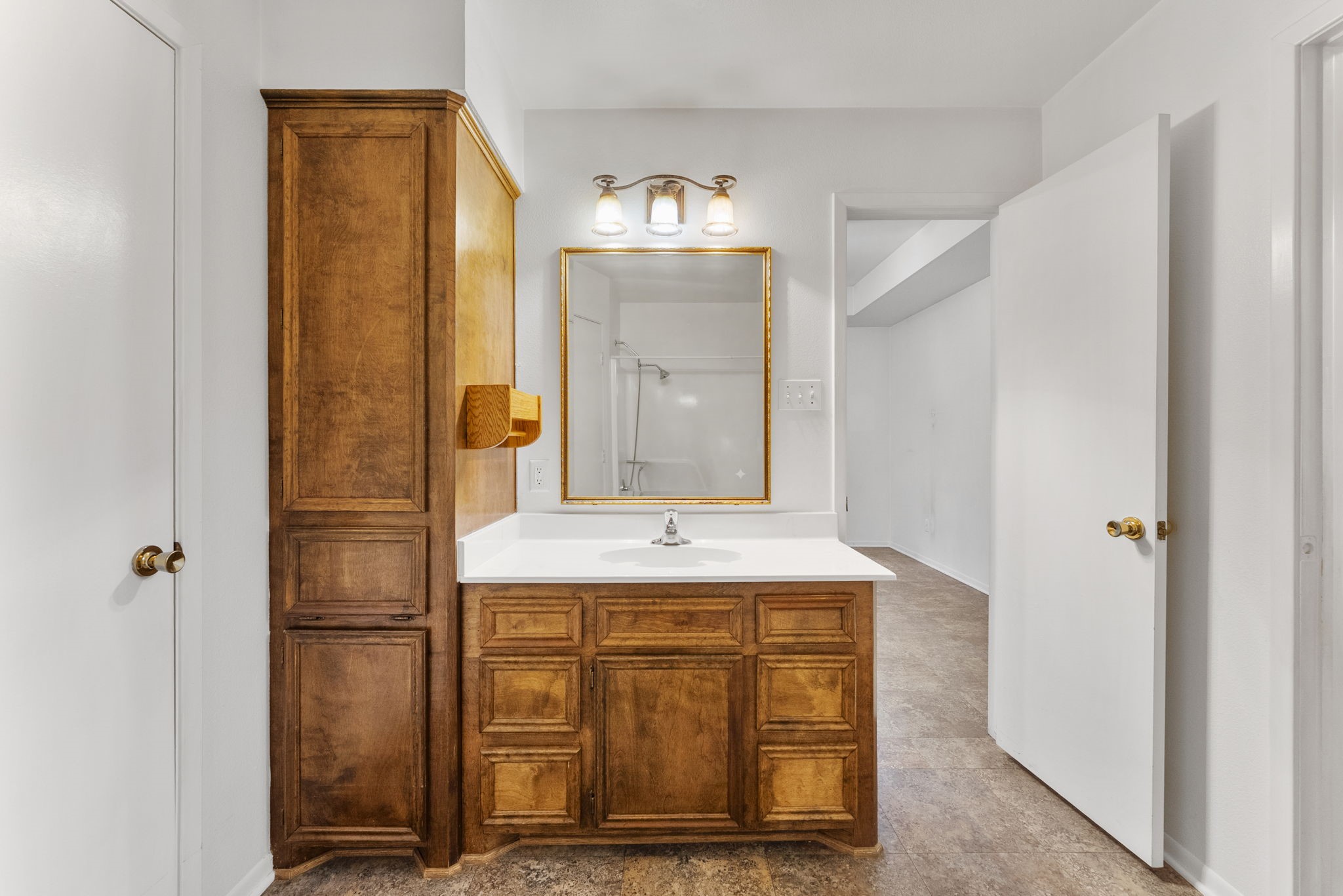 202 Sunset Boulevard Conroe, TX 77303 - Photo 34 of 50 Discover the charm of this primary bathroom, featuring rich wooden cabinetry, a sleek countertop, and elegant lighting that creates a warm, inviting atmosphere.