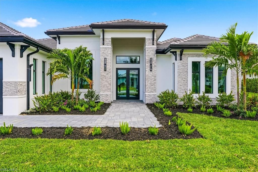 14318 Charthouse Circle Naples, FL 34114 - Photo 2 of 36 a front view of a house with a yard
