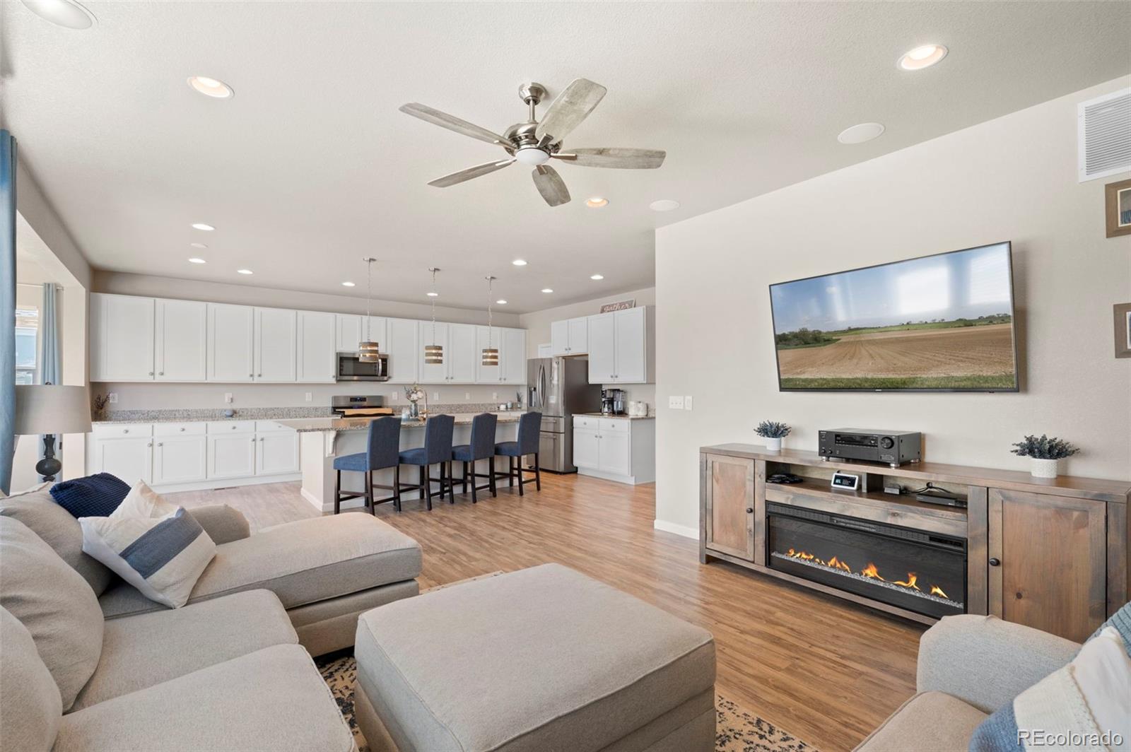 11778 Oneida Street Thornton, CO 80233 - Photo 4 of 30 a living room with furniture and a flat screen tv with kitchen view