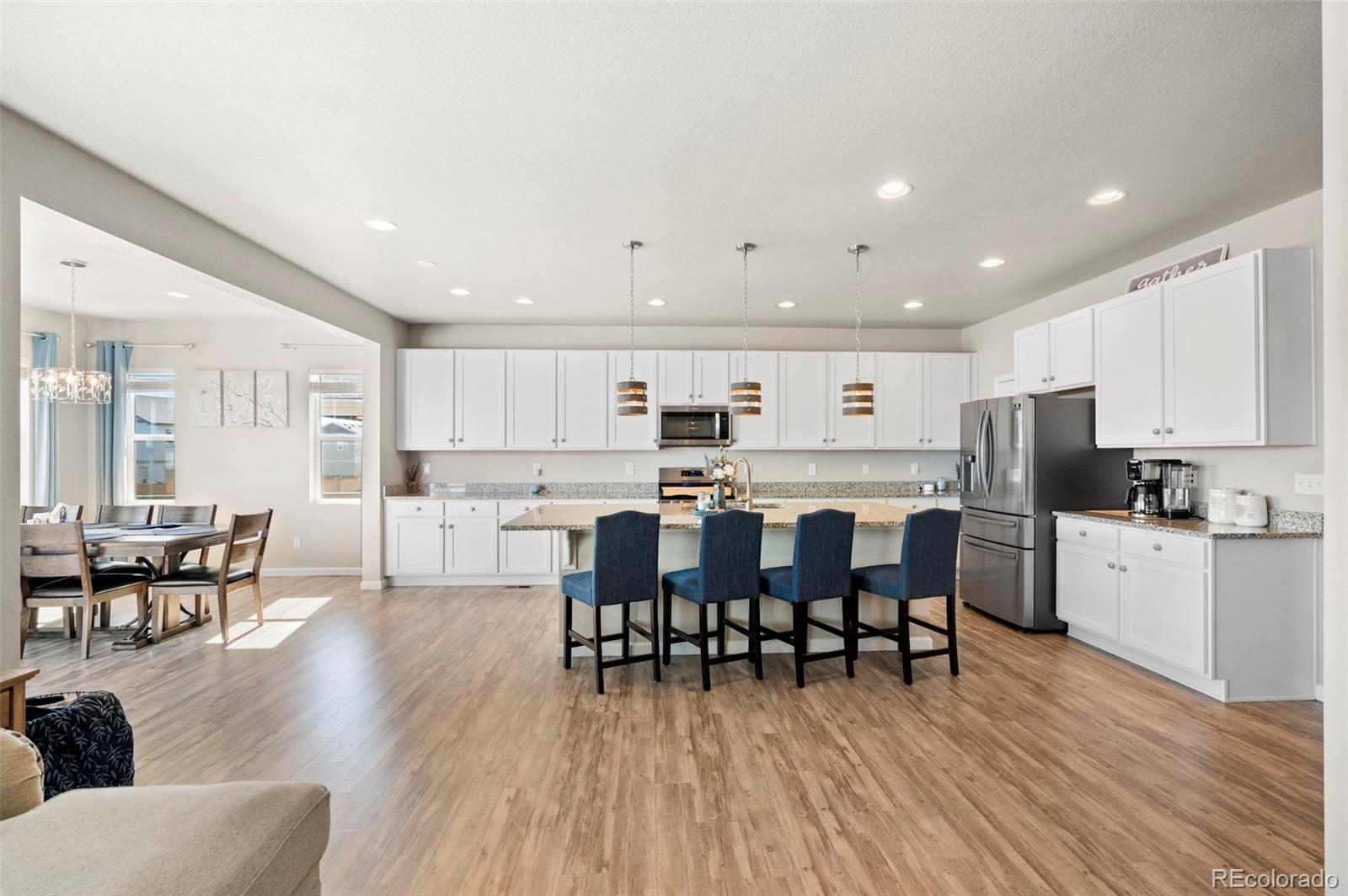 11778 Oneida Street Thornton, CO 80233 - Photo 7 of 30 a large white kitchen with lots of furniture a sink appliances and dining table