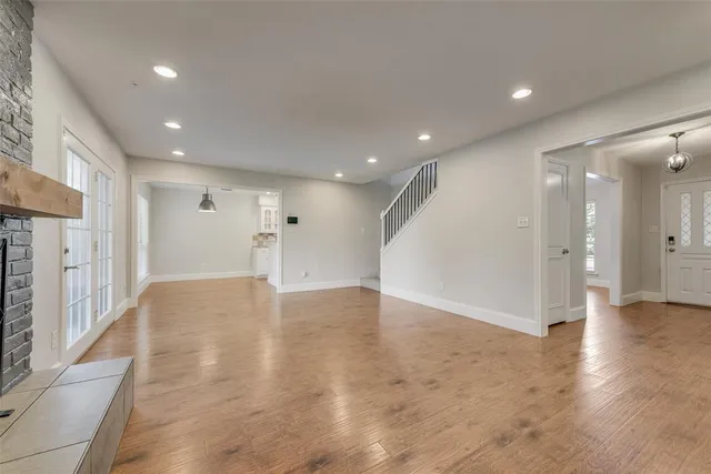 a view of an empty room with wooden floor