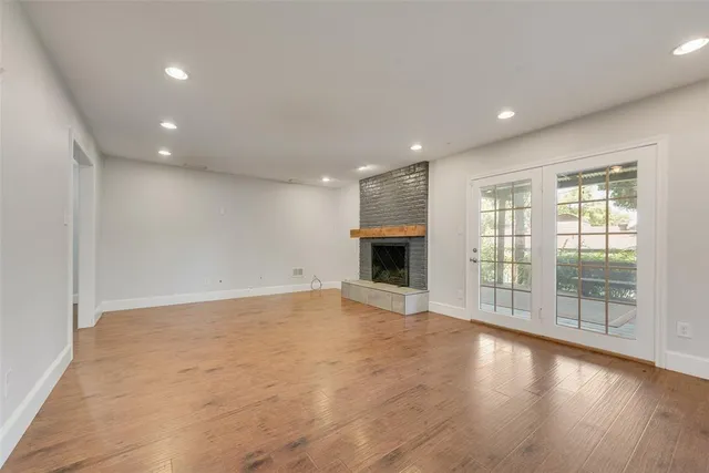 an empty room with wooden floor and fireplace