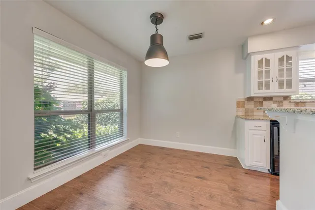 a view of a kitchen with wooden floor and a window
