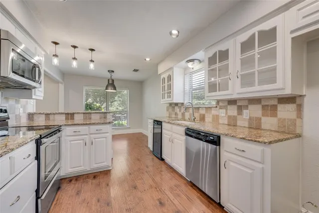 a kitchen with stainless steel appliances granite countertop a stove and cabinets