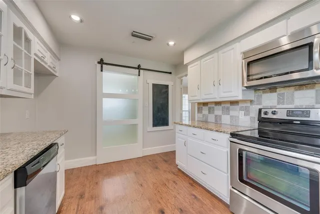 a kitchen with stainless steel appliances granite countertop a stove and a refrigerator