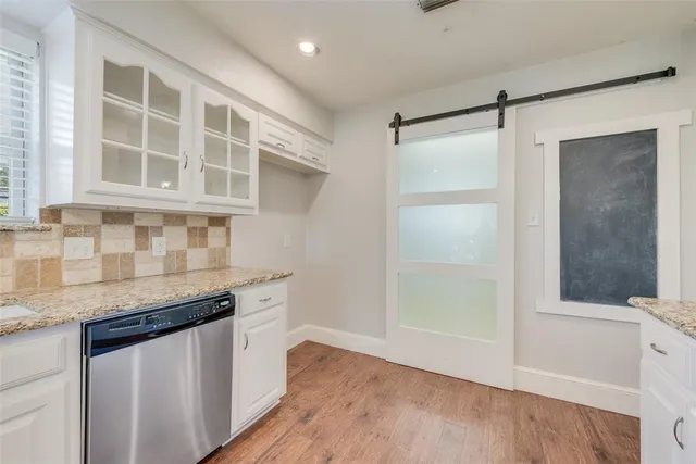 a kitchen with granite countertop a sink and cabinets
