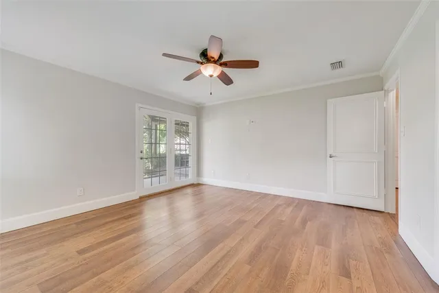 a view of a room with wooden floor and ceiling fan