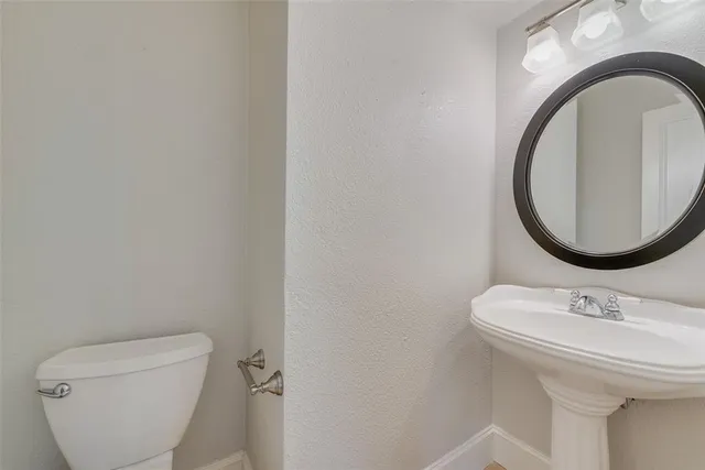 a bathroom with a toilet a sink and a mirror