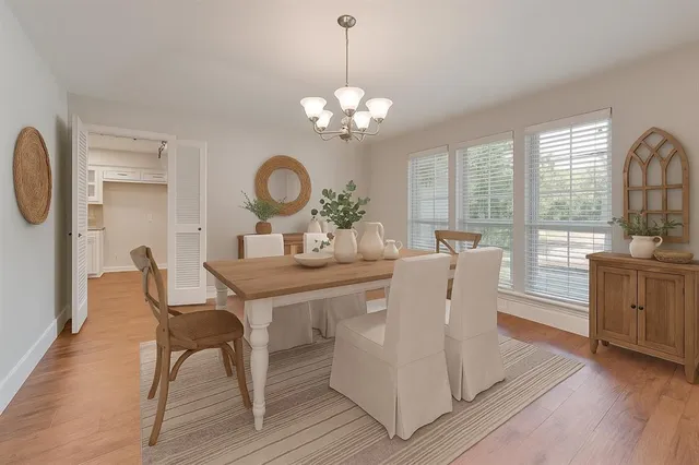 a view of a dining room with furniture a chandelier and wooden floor