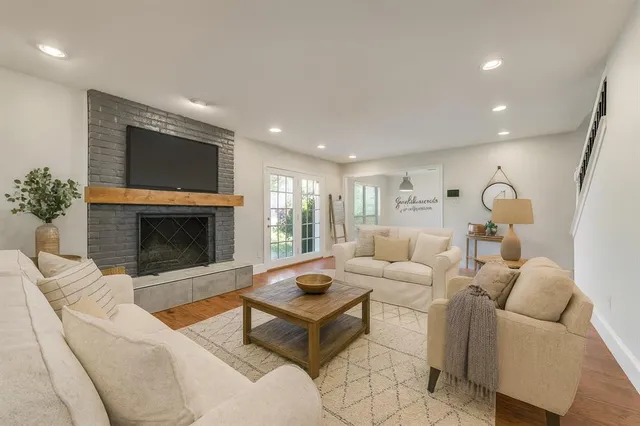 a living room with furniture a fireplace and a flat screen tv