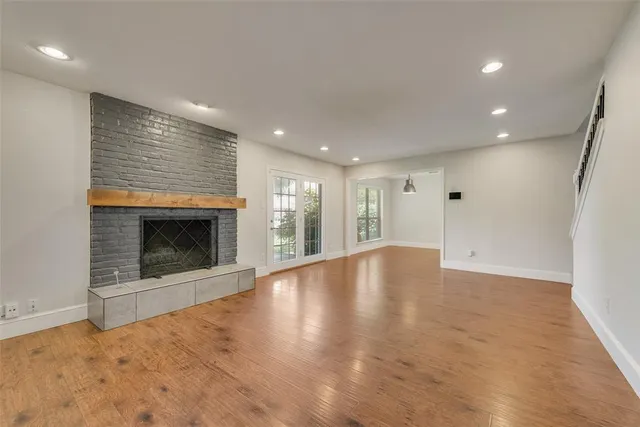 an empty room with wooden floor and fireplace