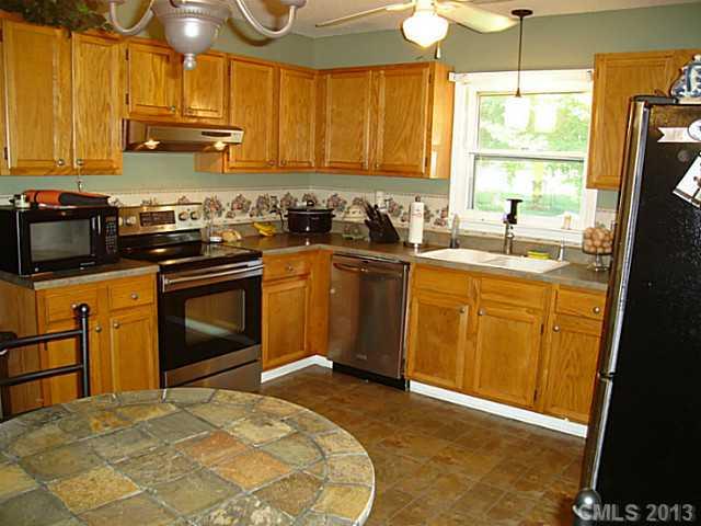 2311 Lawrence Road Clover, SC 29710 - Photo 3 of 8 a kitchen with stainless steel appliances granite countertop a stove a sink dishwasher and a refrigerator with wooden cabinets