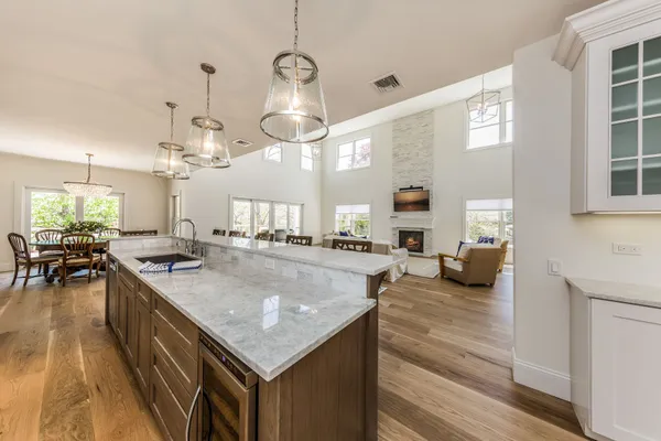 a kitchen with a stove kitchen island and living room view