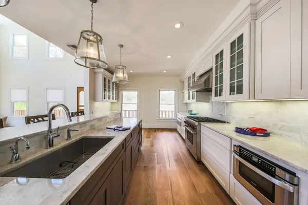 a kitchen with granite countertop a sink stove and cabinets