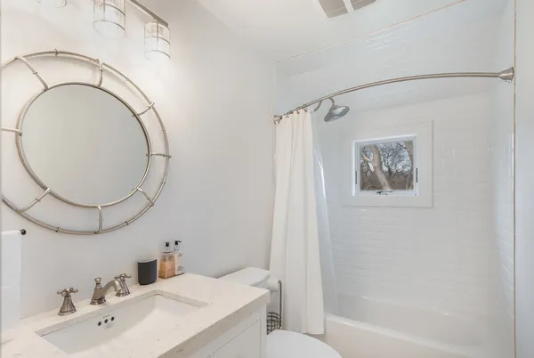 a bathroom with a sink a toilet and a mirror