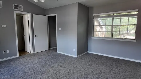 an empty room with windows and closet