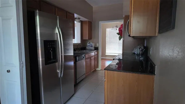 a kitchen with stainless steel appliances granite countertop a refrigerator a stove a sink and a refrigerator