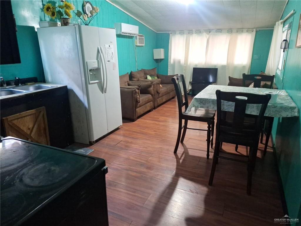 36789 Marshall Hutts Road Rio Hondo, TX 78583 - Photo 4 of 7 a open kitchen with stainless steel appliances granite countertop a refrigerator a stove a sink a dining table and chairs