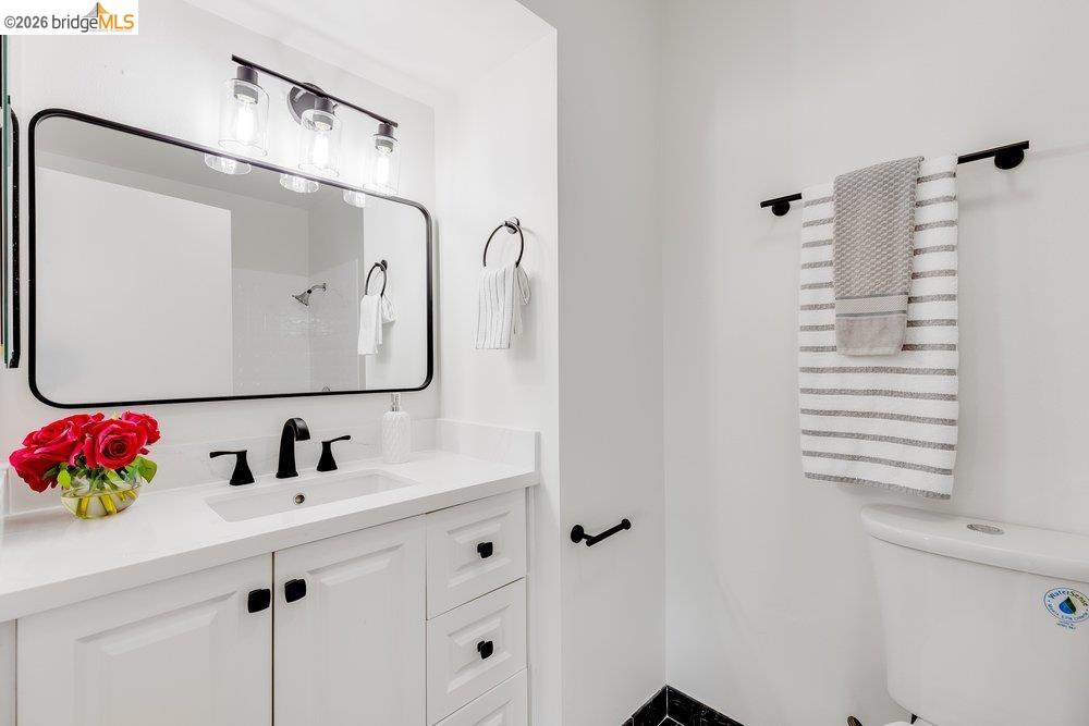 1298 Ribbon Street Foster City, CA 94404 - Photo 55 of 86 Bathroom vanity featuring a quartz countertop, integrated sink, and white cabinetry with matte black hardware