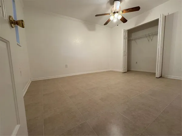 en empty room with windows and chandelier fan