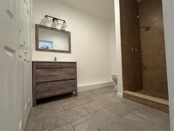 a view of an empty room and chandelier fan