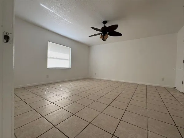 a view of an empty room with stairs and wooden floor