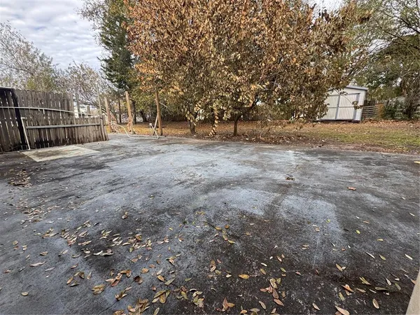 an empty room with windows and chandelier fan