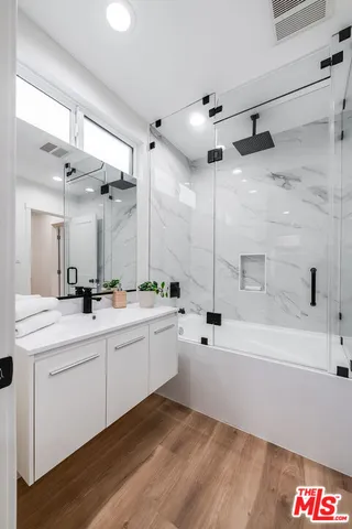 a bathroom with a tub sink and mirror